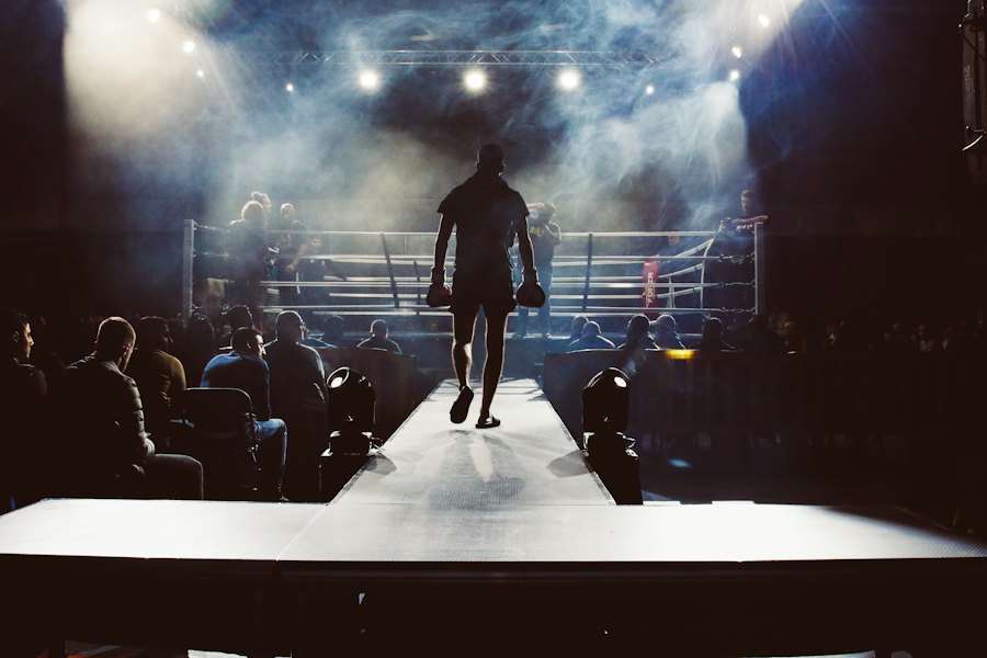 A boxer walking out towards the ring under arena lights